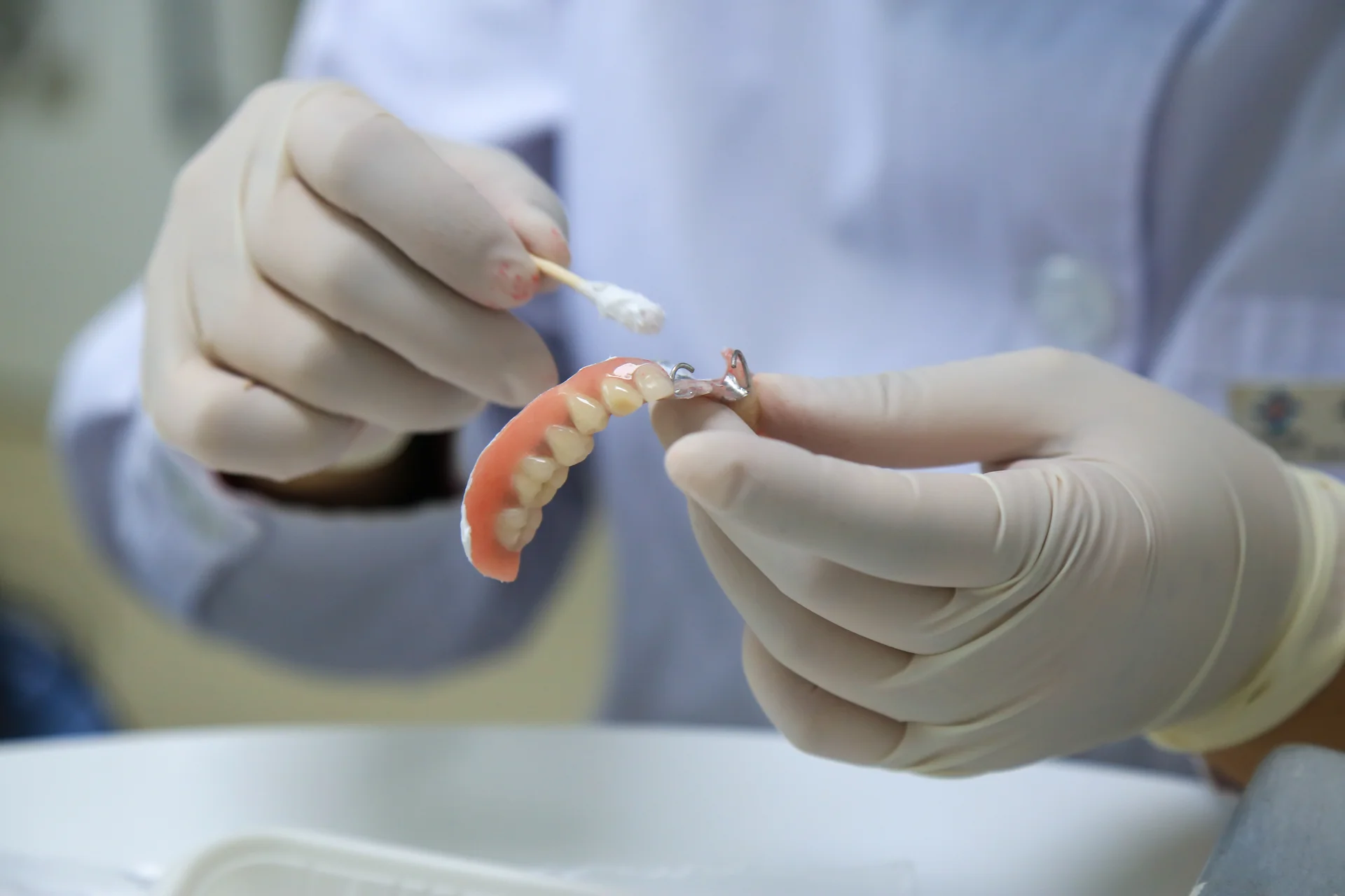 Close-up of a clinician holding a partial denture