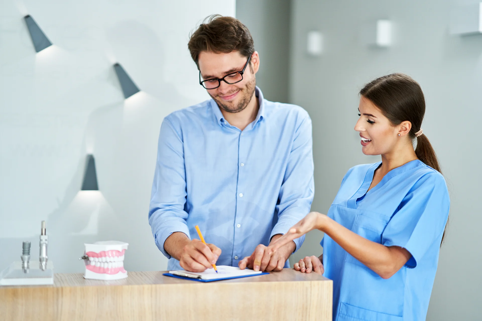 Team member reviewing paperwork with a patient at the front desk