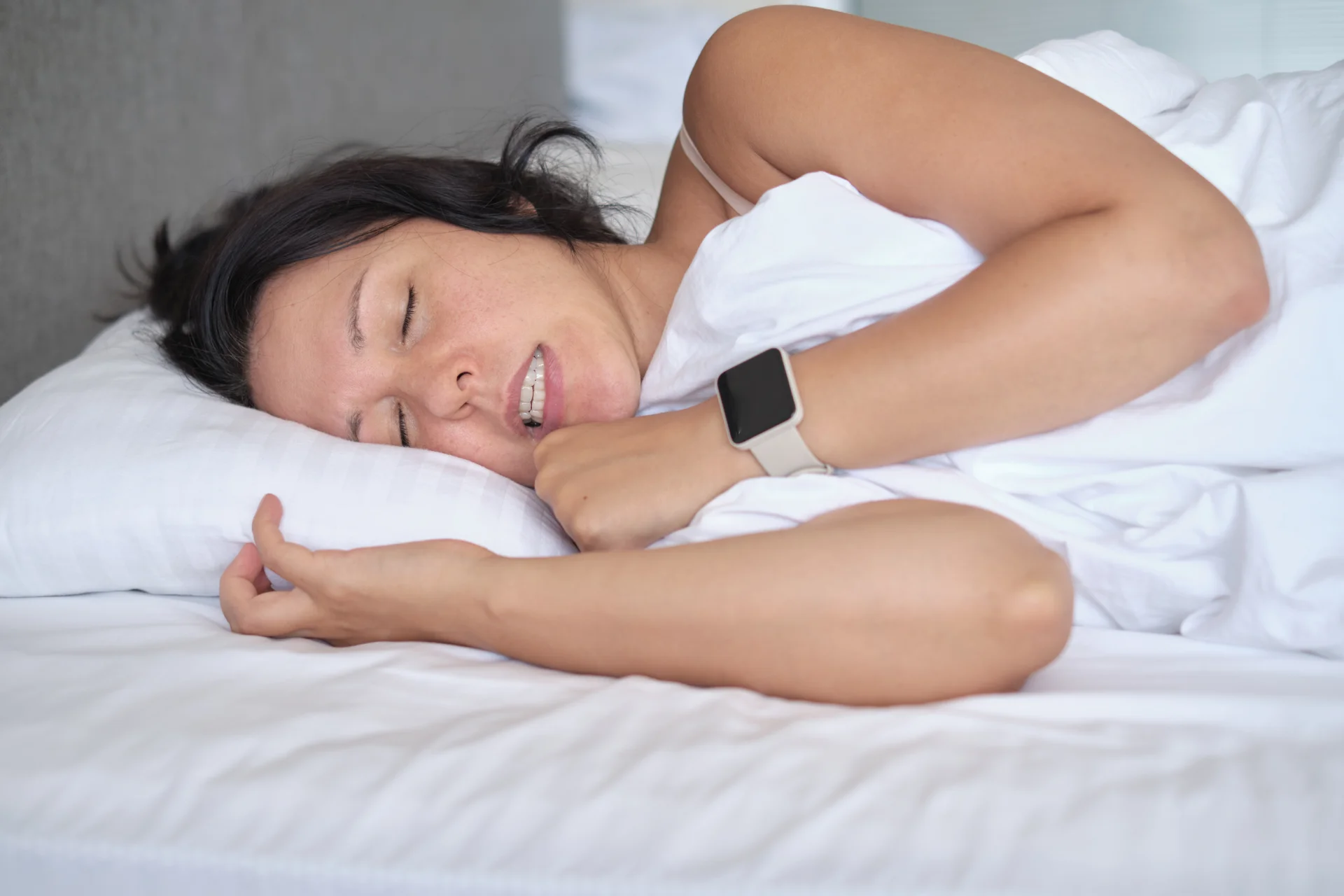 Woman clenching her teeth in bed, showing bruxism