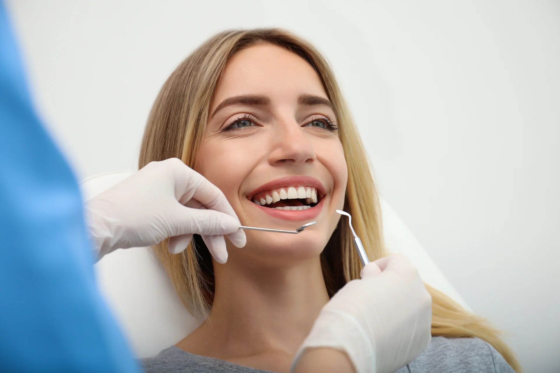 Smiling patient checking her new smile in a hand mirror