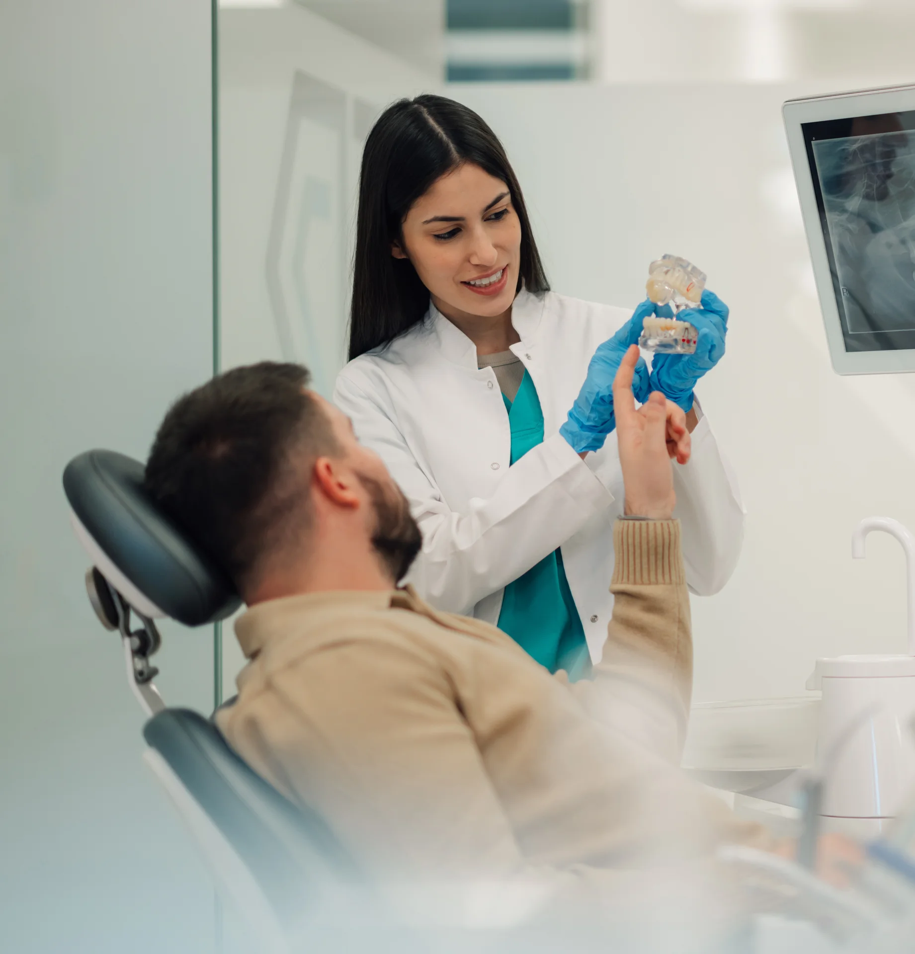 Dentist showing a dental model to a patient during a consultation