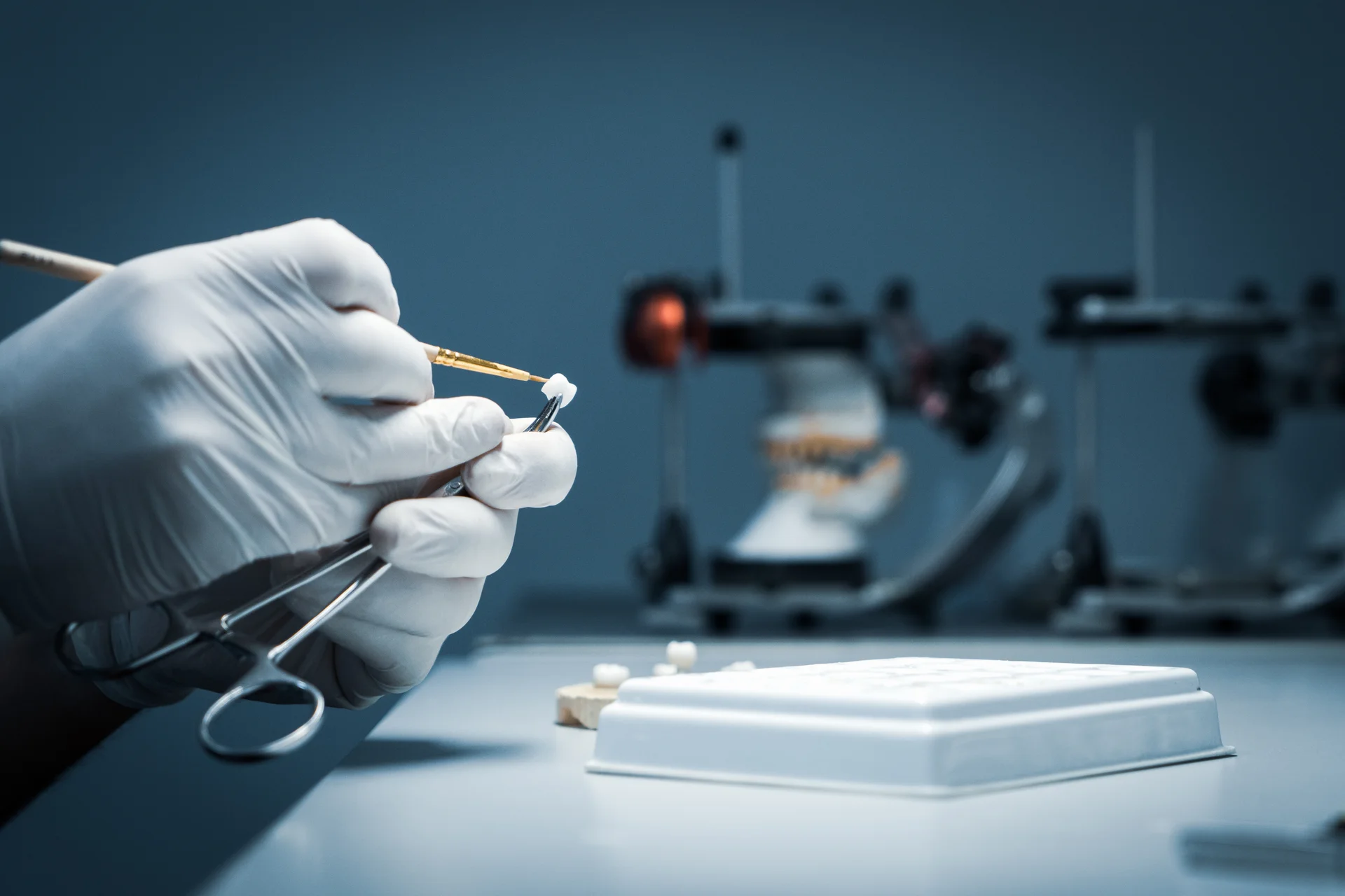 Technician hand-crafting a dental crown in a prosthodontic lab